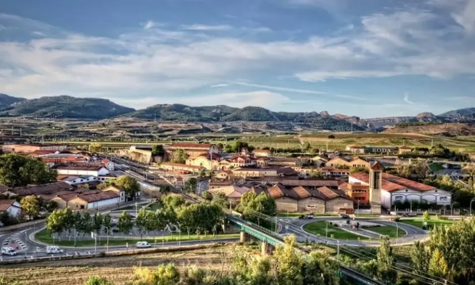 Vista aérea de un pueblo con tejados rojos y montañas al fondo. Se ve la bodega RODA, un buen lugar para añada 2017 rioja.